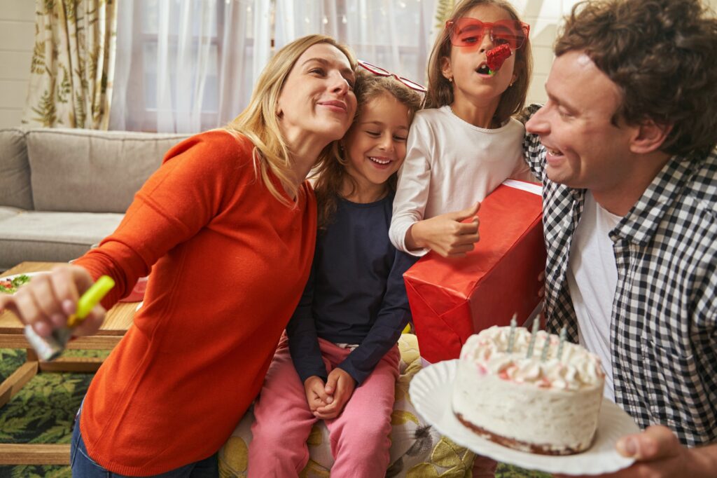 Smiling family having birthday party with cake